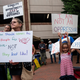 People hold up signs during a rally against “critical race theory” (CRT) being taught in schools at the Loudoun County Government center in Leesburg, Virginia on June 12, 2021.